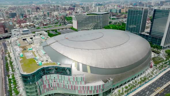 Aerial birds eye shot of big egg building named Taipei Dome and Skyline in  background during daytime, Stock Footage